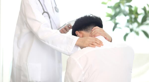 목을 손으로 감싸쥔 사람의 뒷모습